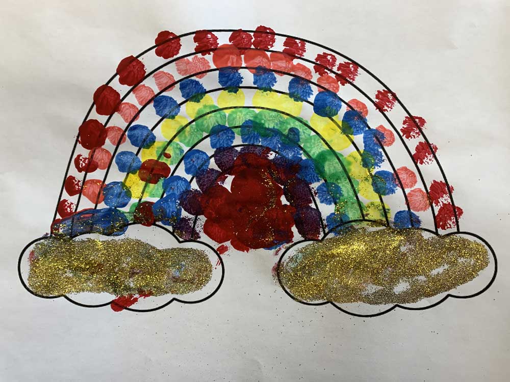 A rainbow made of colored dots and gold leaves.