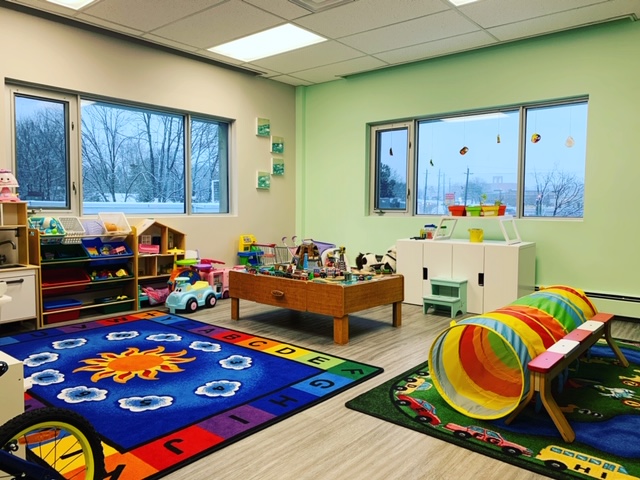 A room with toys and a rug in it