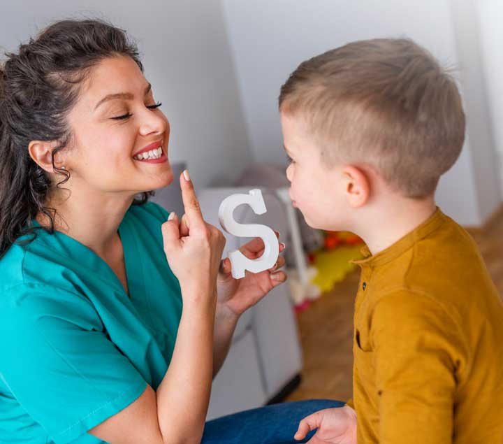 A woman and boy are playing with letters.